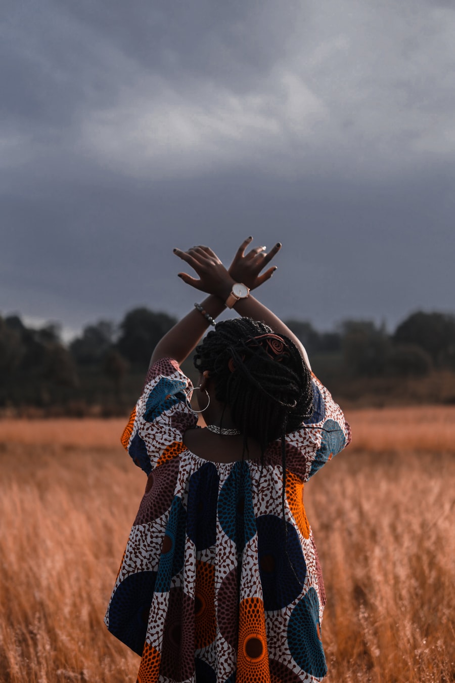 A woman in printed cloth standing in tall grass