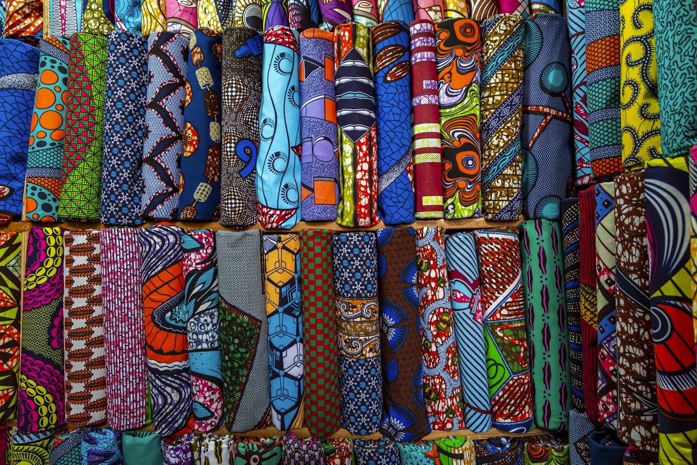 Folded African wax-print textiles in stacked color