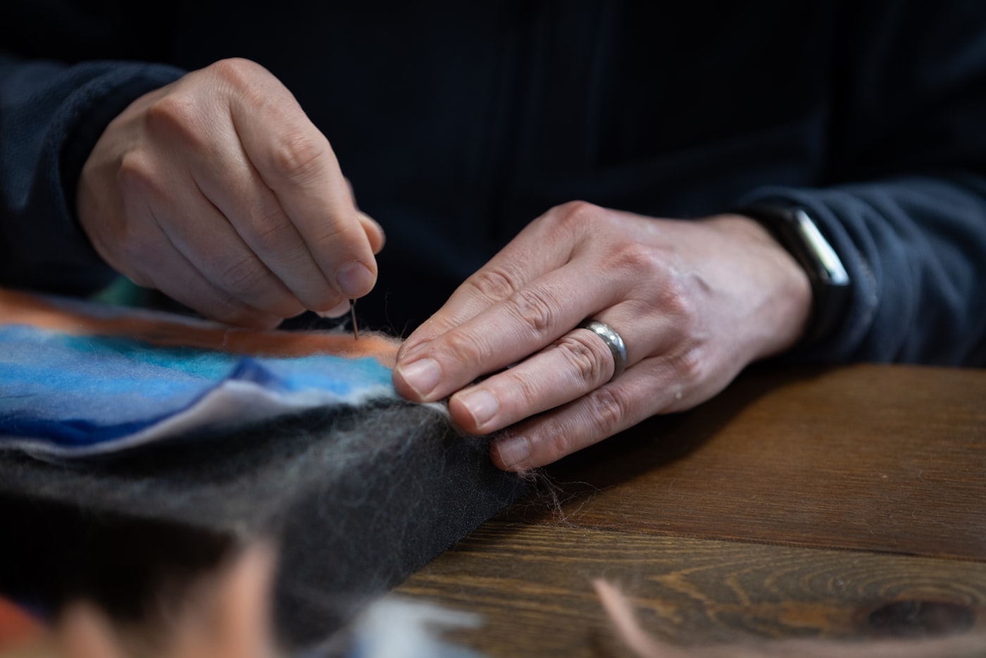 Hands guiding fabric through a sewing machine